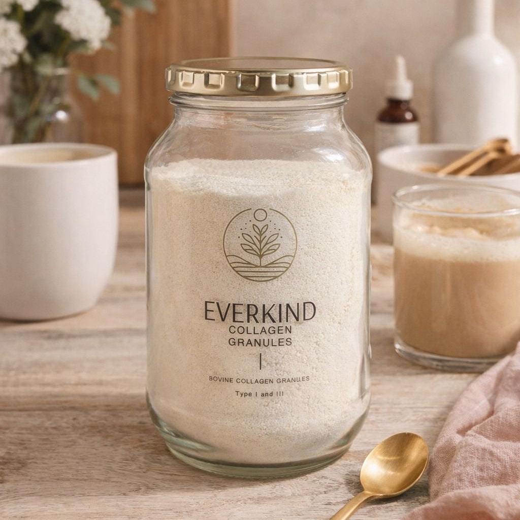 Glass jar of Everkind Collagen Granules on a wooden surface with a cup and spoon in the background.